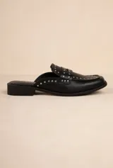 Zuecos negros de símil cuero con tachas en la capellada, taco de 3cm y suela acolchonada.