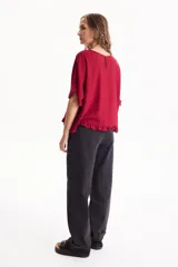 Blusa de lino color crudo, de manga corta con detalles de volados en las mangas y en el ruedo.