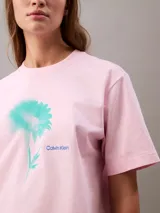 Remera rosa de algodón con cuello redondo y mangas cortas con dobladillo. Estampado de flor celeste en el frente y logo de Calvin Klein.