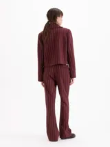 Pantalon de sastreria color bordeaux con diseño de rayas finas verticales blancas, de tiro alto y pierna recta.