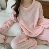 Conjunto de pijama de dos piezas confeccionado en plush suave con textura acanalada. Incluye una remera de manga larga con cuello redondo y un pantalón largo de corte holgado. Es una prenda abrigada ideal para la temporada de invierno.