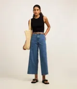 Blusa sin mangas color beige confeccionada en tejido de punto con textura acanalada y cuello redondo.