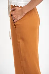 Pantalón de lino color tostado, de corte recto y tiro medio.