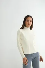 Polera negra de tejido de punto acanalado, con cuello alto y mangas largas.