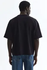 Remera de corte oversized en punto de algodón, con cuello redondo acanalado, hombros caídos y bajo recto.