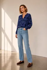 Blusa azul de manga larga con estampado abstracto oscuro, escote en V con cuello mao y cierre frontal de botones.