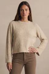 Sweater de punto con textura acanalada vertical, color beige melange, de cuello redondo y manga larga con puños rectos.