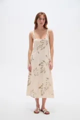 Vestido midi de viscosa color beige con estampado de hojas en tonos verdosos, de corte holgado, con tirantes finos regulables y escote cuadrado.