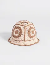 Gorro tipo bucket tejido a crochet con diseño de flores en color beige y marrón.