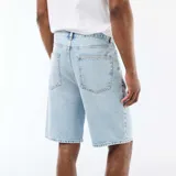 Bermudas de denim de corte clásico en color celeste claro, con bolsillos laterales y traseros, y cierre frontal con botón y cremallera.