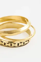 Set de pulseras rígidas de metal dorado, compuesto por tres piezas con diferentes texturas y diseños grabados.