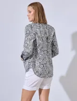 Camisa de algodón estampada en tonos celeste y blanco, con cuello con solapa, abertura central con botones y mangas largas con puños en contraste.