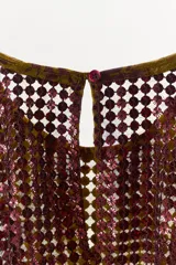 Top estampado de cuello redondo y manga sisa, con detalle de capa superpuesta de tejido con lentejuelas en contraste y cierre posterior con abertura y botón.