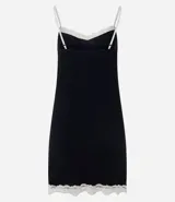 Camisón corto negro de viscolycra, con breteles finos blancos y escote en V decorado con encaje blanco y un pequeño lazo al centro. Presenta detalles de encaje blanco en el ruedo.