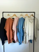 Blusa tipo poncho confeccionada en lino italiano color gris claro, con escote en V y calce amplio.