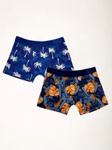Pack de dos boxers de largo medio, uno azul con estampado de palmeras blancas y otro azul marino con estampado de hojas naranjas y azules. Ambos con elástico visible en la cintura con la marca Prili.