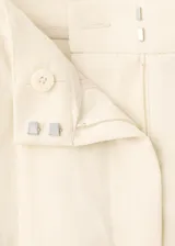 Pantalón largo de tiro medio, color beige, con diseño recto, trabillas para cinto y bolsillos laterales.
