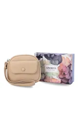 Monedero de mano color beige, confeccionado en material texturizado tipo cuero. Presenta un diseño compacto con cierre perimetral, una correa de muñeca integrada y un bolsillo frontal con solapa y cierre de botón a presión.