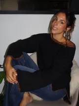 Sweater tejido de punto jersey en color negro, con terminaciones hechas a mano en crochet a contratono con detalles de lurex. Presenta una silueta oversize, mangas acampanadas y cuello a la base.