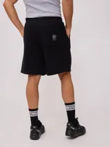 Bermuda deportiva gris confeccionada en 60% algodón y 40% poliéster, con cintura elástica ajustable con cordón.