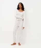 Pantalón de pijama tipo jogger con estampa de corazones pequeños sobre fondo claro, confeccionado en tejido suave al tacto. Presenta cintura elástica con cordón ajustable y puños en los tobillos.