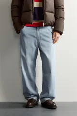 Pantalón jeans de corte relaxed fit, color celeste con efecto lavado, de estilo carpintero con bolsillos laterales y presillas de herramientas.