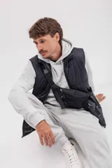 Chaleco puffer color gris topo, con cuello alto y cierre frontal.