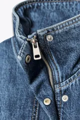 Cazadora estilo bomber confeccionada en tejido denim azul. Presenta cuello subido, cierre frontal con cremallera oculta por solapa, bolsillos laterales de vivo y bajo con acabado elástico.