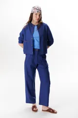 Pantalón de lino azul con corte recto y holgado, tiro alto, pinzas delanteras y pespuntes a contratono.