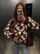 Buzo tejido de algodón con estampado estilo cow print en tonos marrón y tostado, cuello polo marrón con botones, mangas largas y puños acanalados.
