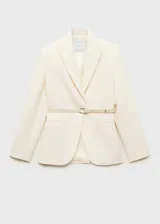 Blazer color crema con cuello de solapa, hombros marcados, bolsillos delanteros, cinturón desmontable y forro interior.
