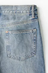 Jeans de cinco bolsillos en denim de algodón rígido. Corte holgado de cadera a bajo con pierna recta amplia y tiro caído. Modelo de cintura estándar con cierre de botones. Presenta un lavado celeste claro con efecto degradado o 'dip-dye' en la parte inferior.