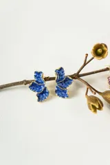 Aros de diseño orgánico con forma de pétalos en color azul intenso con textura esmaltada y bordes dorados.