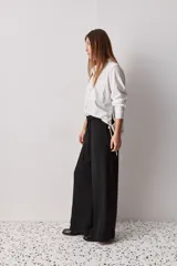 Pantalón wide leg de color negro, con cintura de tiro alto, lazo ajustable y caída fluida.
