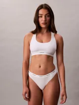 Colaless blanco de algodón con textura de canalé fino y cintura elástica con logo Calvin Klein. Corte ajustado con pierna alta y cobertura mínima.