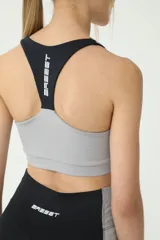 Top deportivo negro y gris con costuras blancas y logo BASSET 00,S estampado en la espalda.