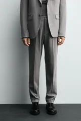 Pantalón de traje corte slim fit, color azul marino con textura sutil. Cuenta con bolsillos laterales, bolsillos traseros con botón y cierre frontal con cremallera y botón.