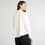 Camisa blanca de corte holgado con cuello clásico y mangas largas.