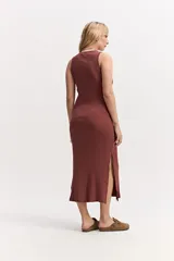 Vestido largo de morley color marrón, con escote redondo, silueta al cuerpo y aberturas laterales en el ruedo.