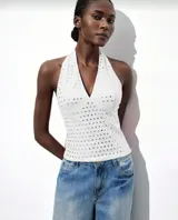 Top halter blanco con escote en V y apliques metálicos plateados.