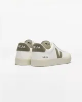 Championes Veja modelo Campo, de cuero ChromeFree color blanco con detalles en verde oliva en el logo lateral y el talón. Presentan suela de goma texturizada y cierre con cordones.
