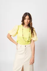 Blusa verde con cuello redondo y mangas cortas abullonadas.