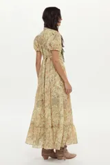 Vestido largo de algodón con estampado floral en tonos beige y verde, mangas cortas abullonadas, cuello camisero y lazo ajustable.