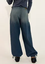 Pantalon de jean estilo wide leg con diseño de tiro medio, bolsillos laterales y detalle de costura horizontal a la altura de la cadera que genera un efecto de volado sutil.