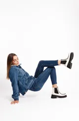 Botinetas de cuero vacuno color blanco tiza, con elásticos laterales negros, suela de goma antideslizante y plataforma con taco cuadrado.