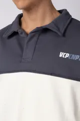 Buzo tipo polo de calce relajado con diseño de bloques de color en tonos marrón y blanco. Presenta cuello polo, cierre frontal parcial y logo estampado en el pecho. Confeccionado en tejido pesado con estructura.