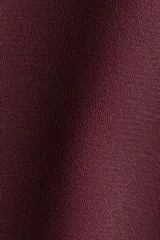 Pollera corta de tela fluida color bordó, con cintura elástica y doble capa con vuelo en el ruedo.