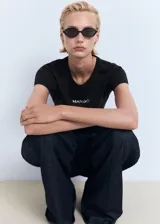 Camiseta de punto color negro, de corte recto, con cuello redondo, mangas cortas y estampado frontal con el texto "MANGO".