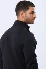 Buzo de tejido fino en hilo de algodón, color rosado, con cuello alto y cierre frontal parcial con detalle en cuero. Presenta puños y ruedo acanalados y un pequeño logo bordado en el pecho.