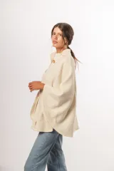 Capa cruda de lana merino uruguaya, con botones de madera y cuello adaptable.